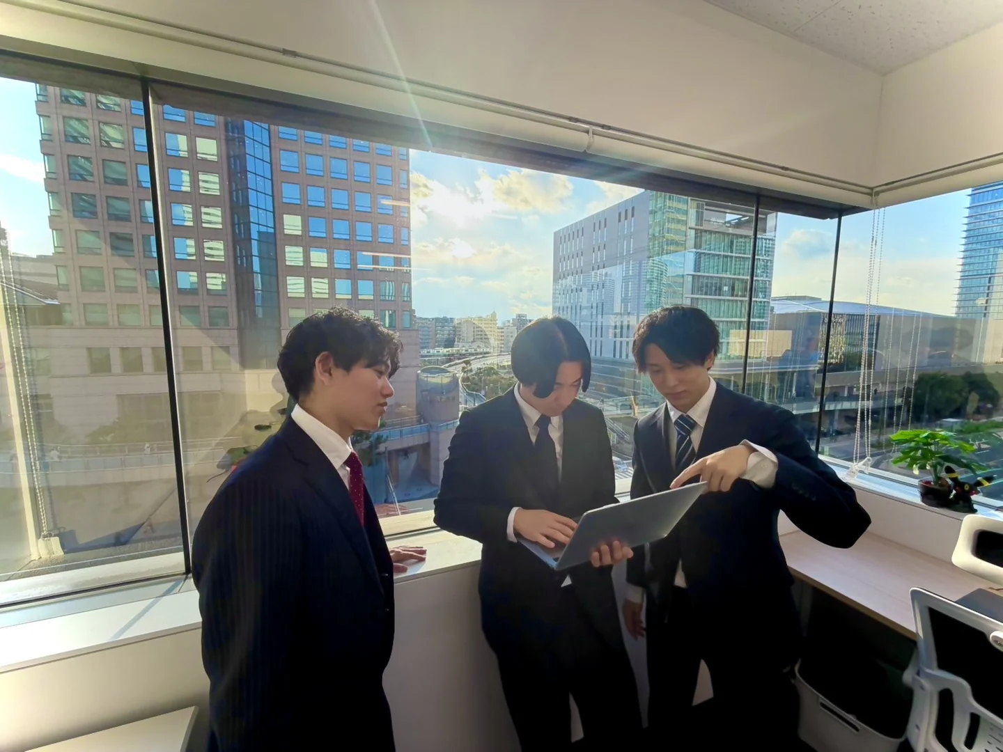 窓際で資料を確認するメンバー