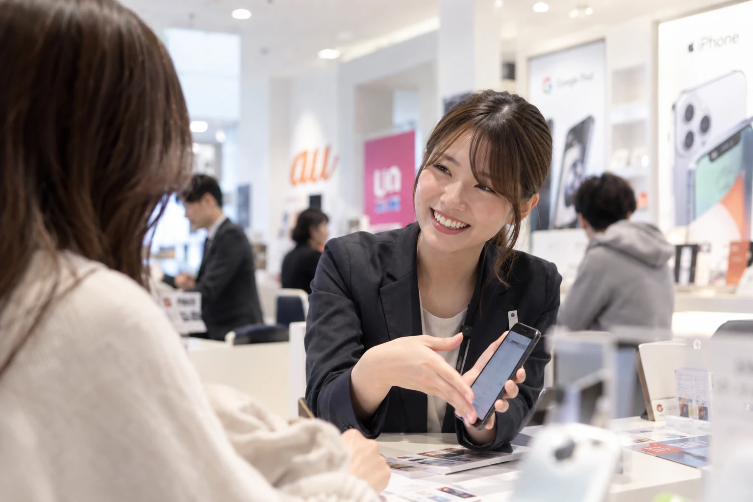携帯ショップでお客様にスマートフォンを案内する接客のイメージ
