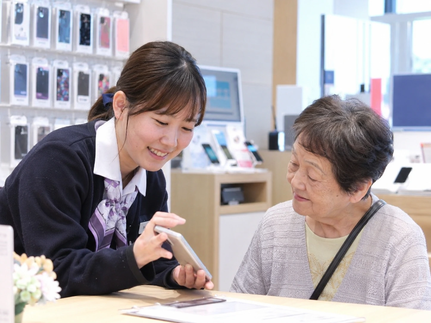 店頭でお客様にスマートフォンを案内する接客風景